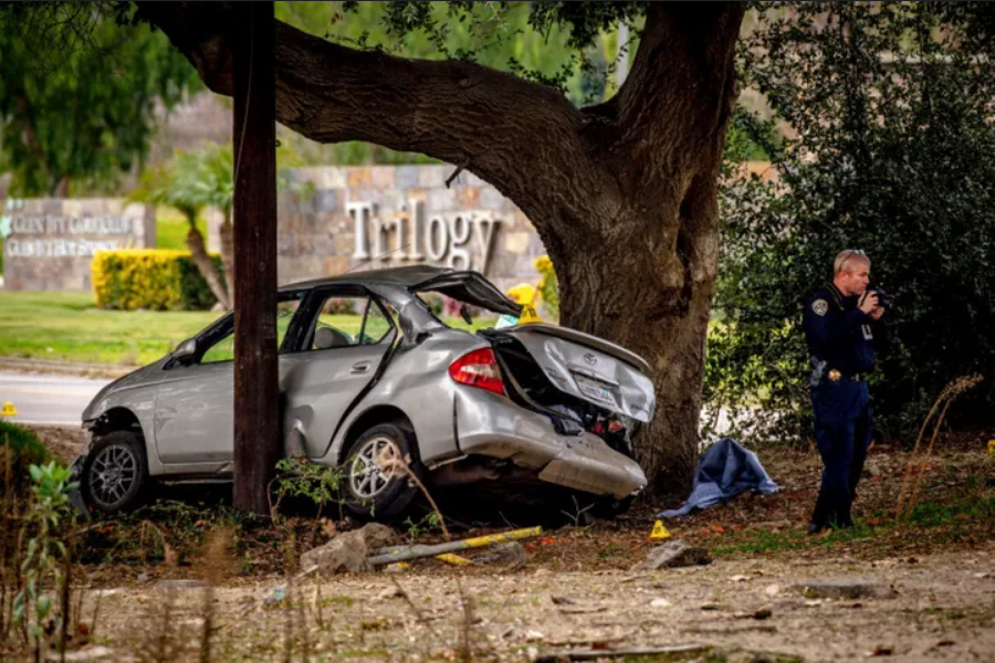 An officer with the California Highway Patrol's (CHP) Multidisciplinary Accident Investigation Team (MAIT) investigates the scene of a deadly crash in the Temescal Valley, south of Corona, California., Monday, Jan. 20, 2020.
Watchara Phomicinda/The Orange County Register via AP