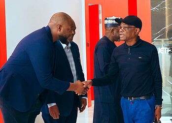 African business professionals shaking hands in a modern office setting, showcasing networking and collaboration.