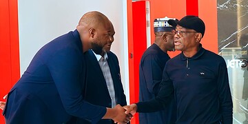 African business professionals shaking hands in a modern office setting, showcasing networking and collaboration.