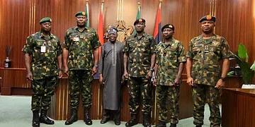 Nigeria military officers meeting government officials for national security briefing in an official government setting.