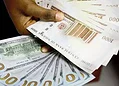 Stacks of British currency notes, including £100 and £50 bills, held in a person's hand, symbolising wealth, financial success, or cash flow.