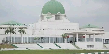 Modern white government building with a green dome, tropical palm trees, and clear skies in the background, reflecting classical architecture and tropical urban development in a coastal city.