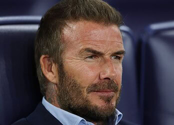Focused middle-aged man with a beard in a sports stadium, reflecting concentration and determination, ideal for sports, leadership, or motivation keywords.