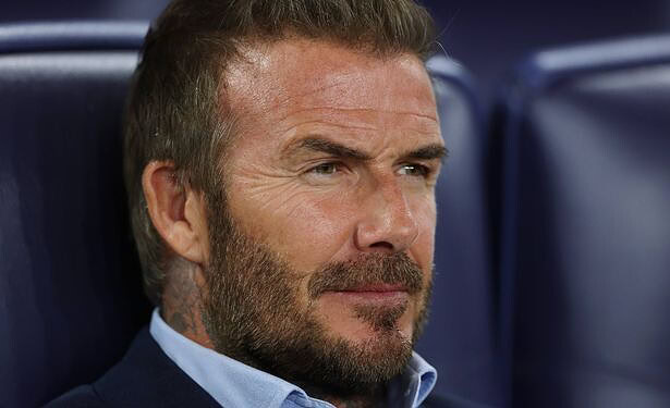 Focused middle-aged man with a beard in a sports stadium, reflecting concentration and determination, ideal for sports, leadership, or motivation keywords.