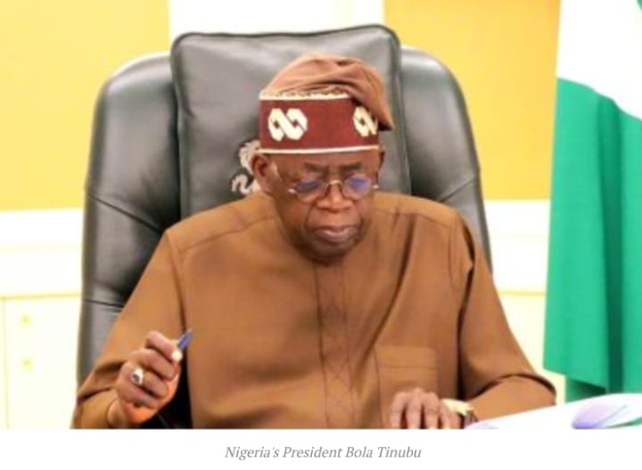 1. Nigerian President Bola Tinubu seated at desk, wearing traditional attire and glasses, in a formal government setting.