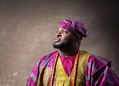 Elegant African man in traditional colourful attire, looking thoughtfully into the distance, symbolising cultural pride and heritage, suitable for articles on cultural fashion and identity.