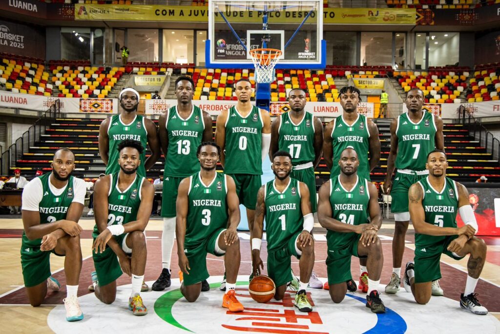 Nigeria basketball team posing for team photo during a game at an indoor stadium, showcasing athletes in green jerseys, highlighting sports news, basketball competitions, and Nigerian sports excellence.