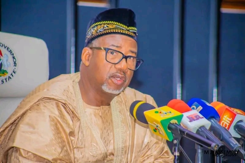 Elevated image of a Nigerian official addressing the media at a press conference, showcasing leadership in governance and political transparency.