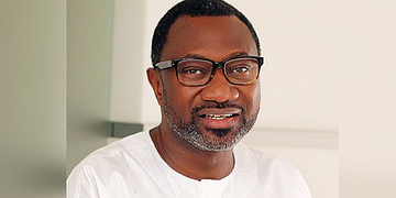 Clergyman wearing glasses smiling indoors, portrait representing leadership and community support for Freelanews audience.