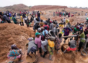 Large group of people working together on construction or excavation project in a rural area, showcasing community effort and labour.