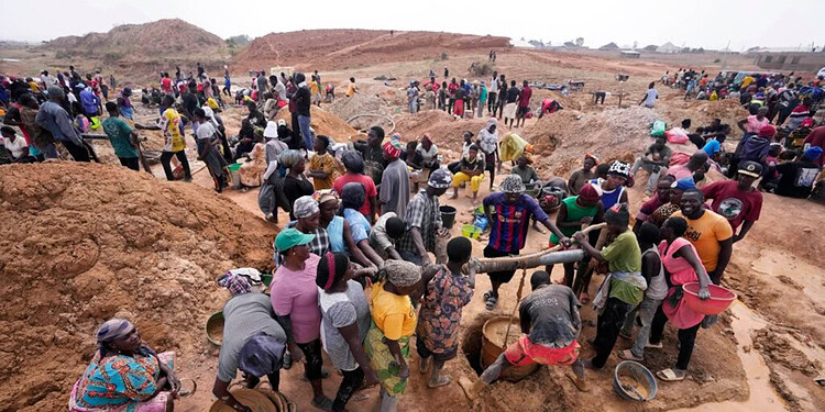 Large group of people working together on construction or excavation project in a rural area, showcasing community effort and labour.