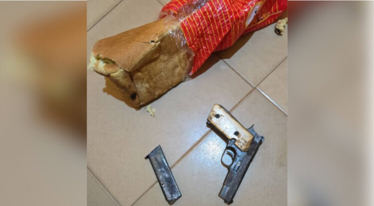 Unsecured firearm and ammunition on tiled floor alongside a torn bread bag, highlighting safety hazards and the importance of gun security in homes.