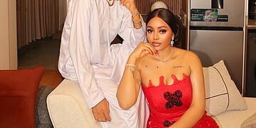 Stylish young man and woman dressed elegantly in a modern interior setting, showcasing fashion and lifestyle content.