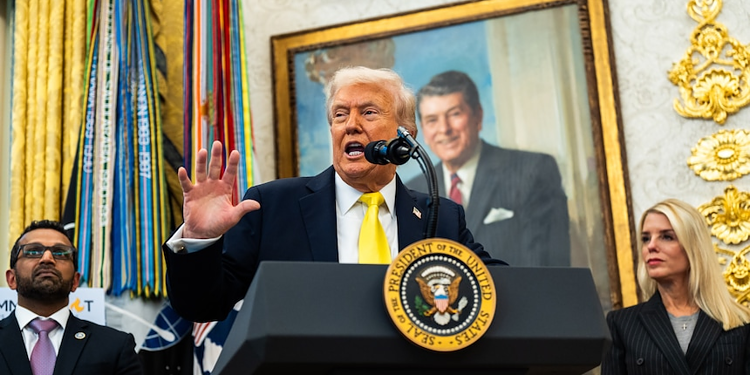 Donald Trump speaking at a podium with the presidential seal, flanked by his advisors, in a room decorated with gold accents and large portraits.