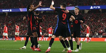 Celebrating FC Barcelona players during a UEFA Champions League match at Estádio José Alvalade, Lisbon. The team shows unity and excitement after scoring against SL Benfica.
