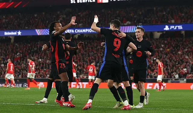 Celebrating FC Barcelona players during a UEFA Champions League match at Estádio José Alvalade, Lisbon. The team shows unity and excitement after scoring against SL Benfica.