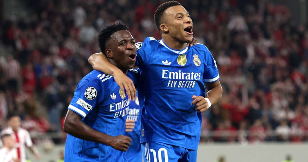 Football players in blue Real Madrid jerseys joyfully celebrate a goal on the pitch, highlighting team spirit and success in a high-stakes match.